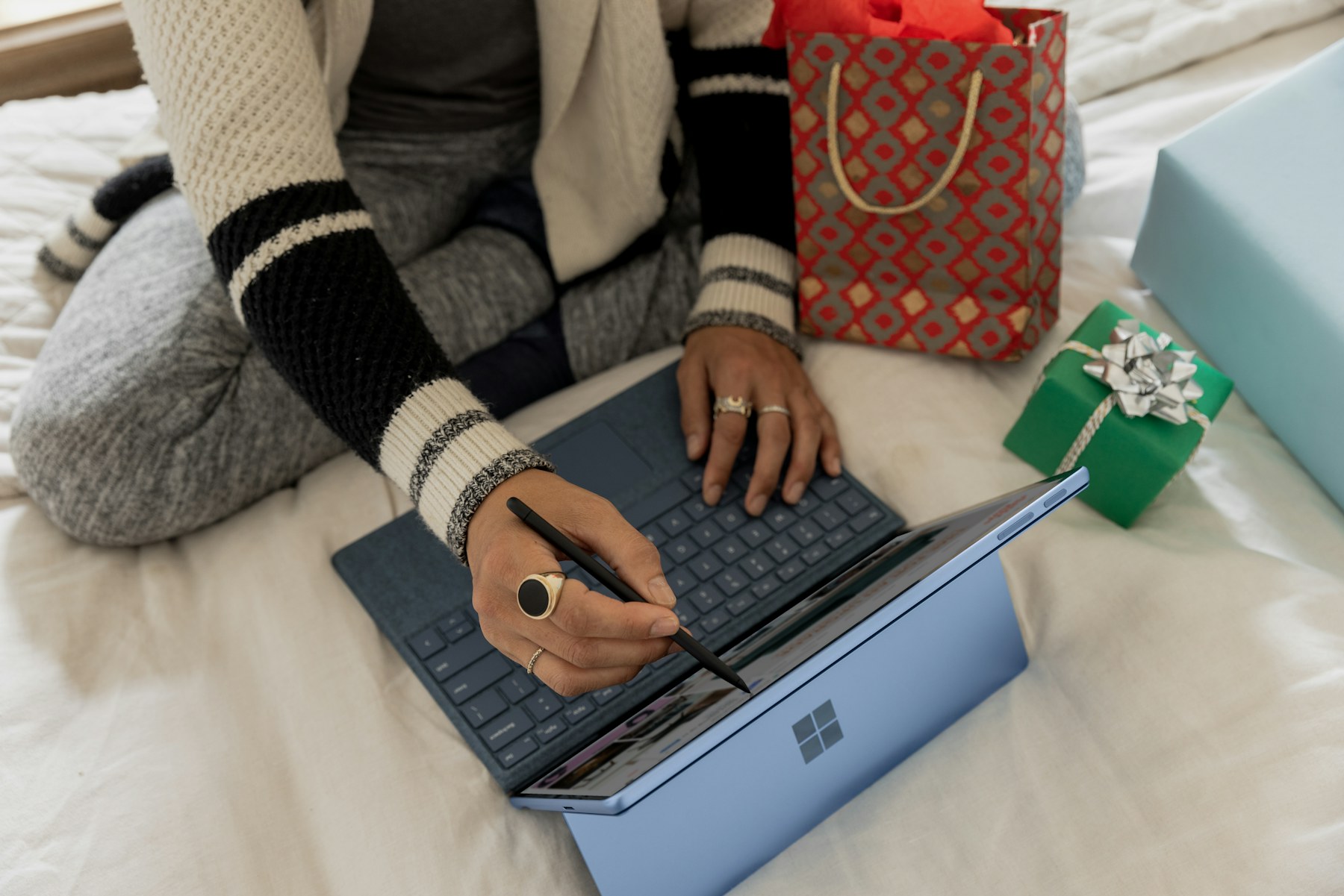 Persoon vergelijkt producten en prijzen op een laptop aan een lichte werktafel